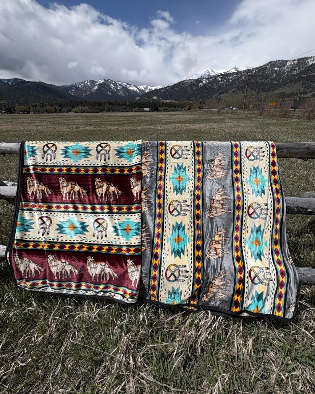 Two horse-pattern Southwestern-style blankets on a ranch fence