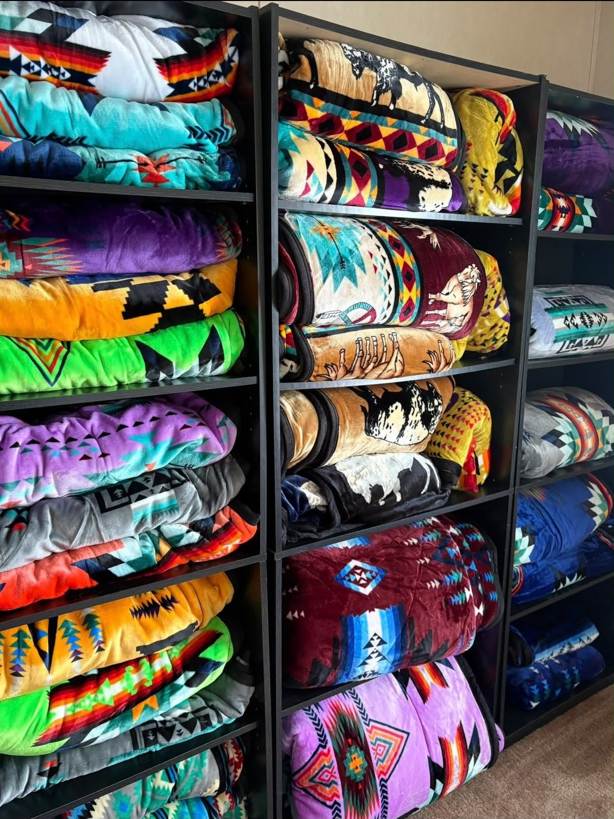 Shelves of rolled, colorful patterned blankets